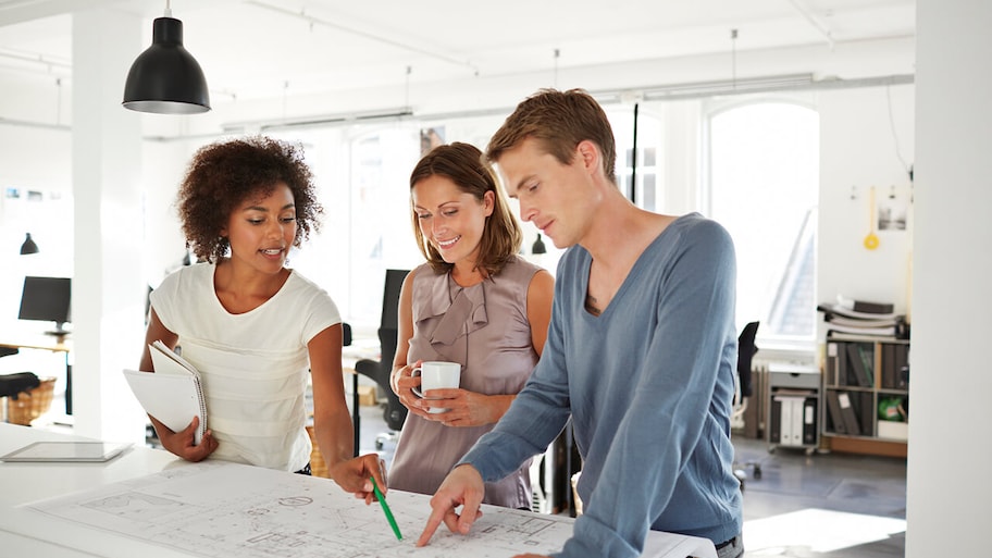 architect discussing home plans in office with homeowner clients