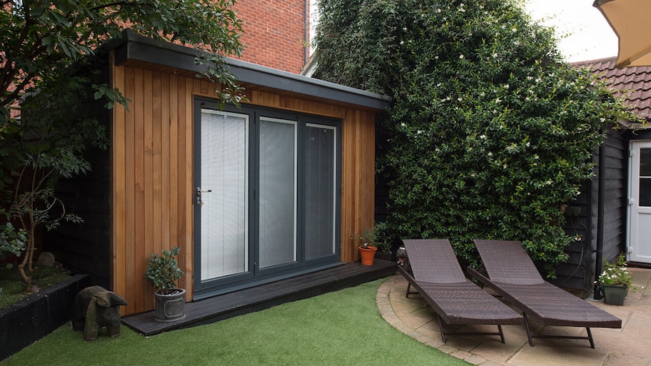 modern home with artifical turf lawn in backyard