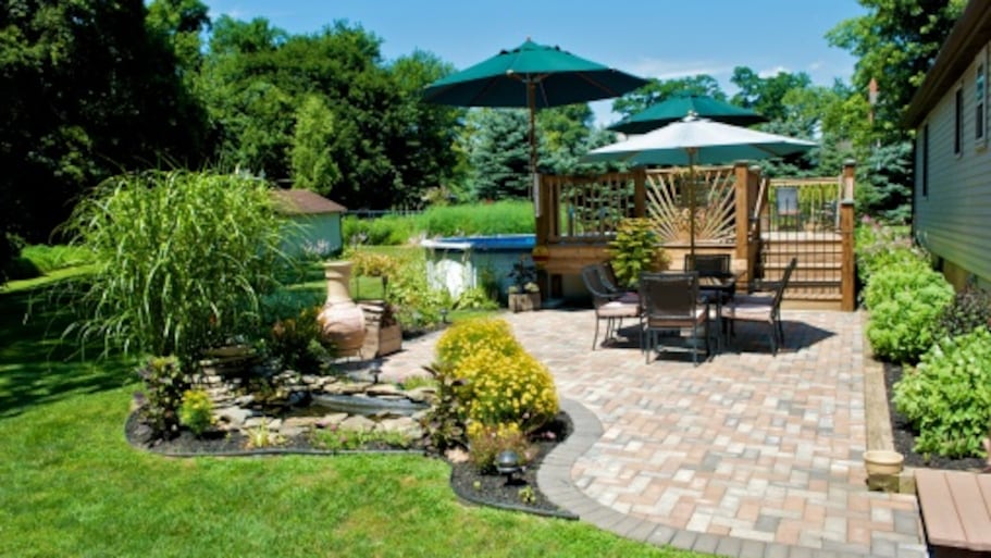 Sunny backyard with brick patio and a pond