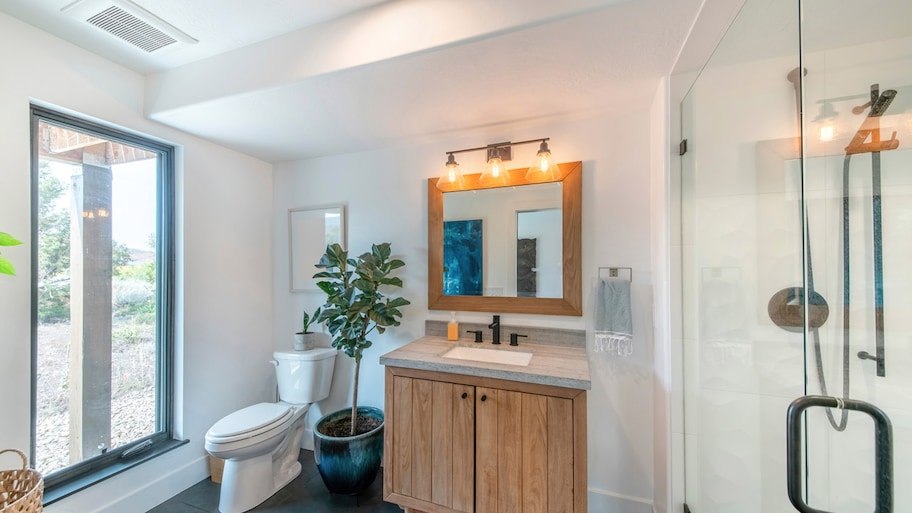 A modern bathroom with a large window and an exhaust fan