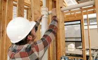 plumber installing pipes in a new build