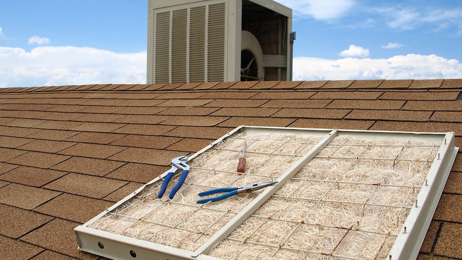 swamp cooler being installed on roof of house