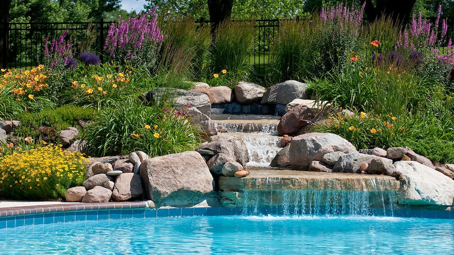 waterall feature with landscaping in a backyard swimming pool